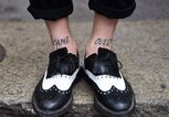 Tattoo Schriftzug am Schienbein | © Getty Images | GABRIEL BOUYS 