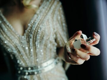 Frau mit Parfum in der Hand | © iStock | Constantinis