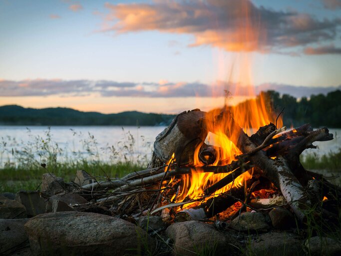 Sommer Lagerfeuer und See bei Sonnenuntergang  | © iStock | Onfokus