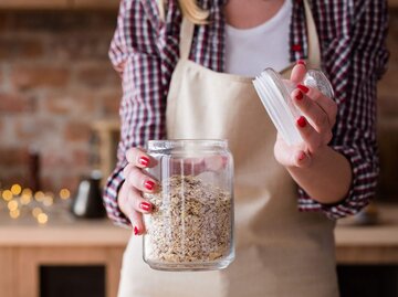 Frau mit einem Glas mit Haferflocken | © iStock | golubovy