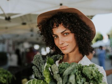 Hübsche, junge Frau auf dem Wochenmarkt mit Grünkohl | © iStock | Rawpixel