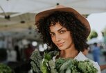 Hübsche, junge Frau auf dem Wochenmarkt mit Grünkohl | © iStock | Rawpixel