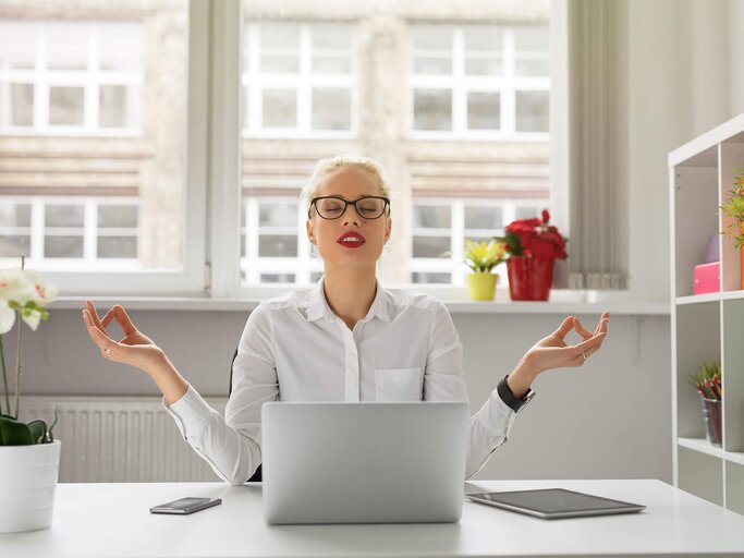 Frau, die im Büro meditiert | © iStock | grinvalds