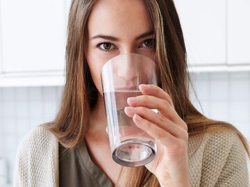 Frau trinkt Wasser aus einem Glas | © iStock | SanneBerg