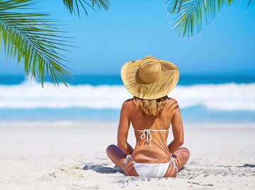 Frau im Bikini mit Sonnenhut | © iStock | PeopleImages