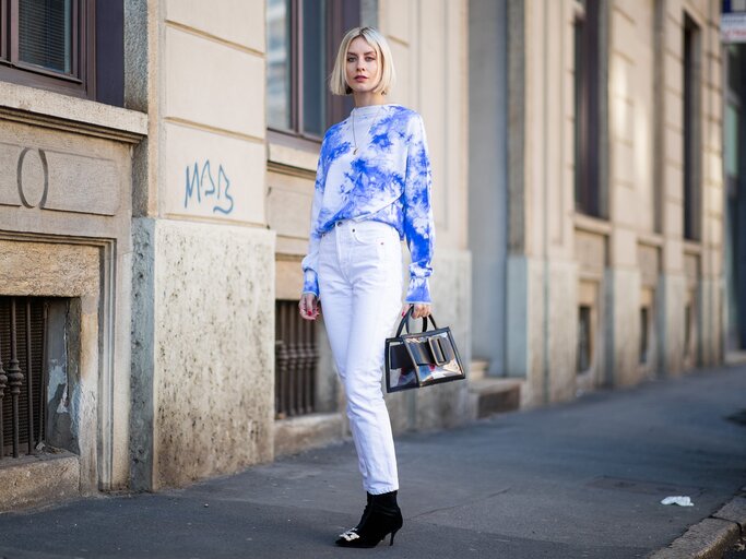 Lisa Hahnbueck in einem Outfit mit Batik-Top und weißer Jeans | © Getty Images | Christian Vierig