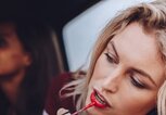 Frau schminkt sich im Autospiegel mit rotem Lippenstift | © iStock | jacoblund