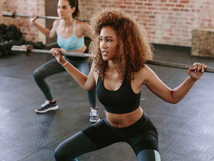 Frauen trainieren Squats mit Langhantel | © iStock | Jacob Ammentorp Lund