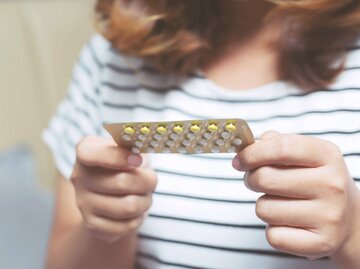 Frau hält Anti-Baby-Pille in den Händen | © iStock | Rattankun Thongbun