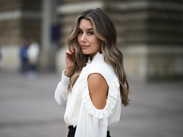 Influencerin Janina Pfau mit Babylights im Haar und Streetstyle mit weißer Bluse in Hamburg  | © Getty Images | Jeremy Moeller