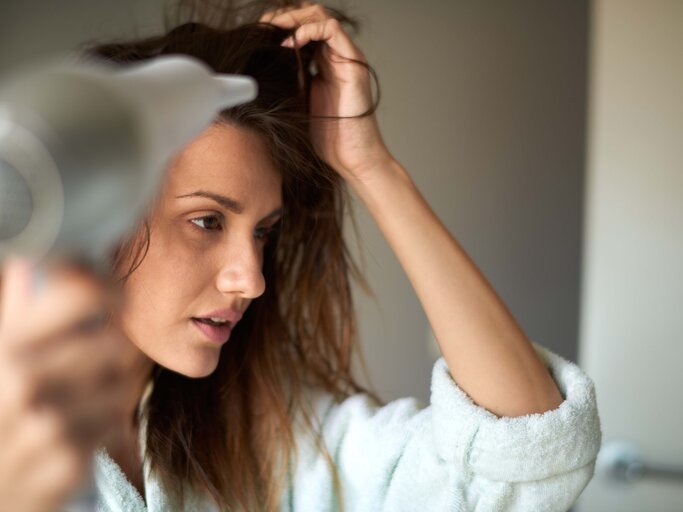 Haare föhnen - Frau föhnt sich die Haare | © iStock | EXTREME-PHOTOGRAPHER