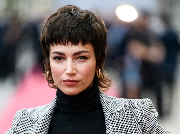 Schauspielerin Úrsula Corberó mit Vokuhila, schwarzem Rollkragenpullover und grauem Hosenanzug dem Roten Teppich beim 67. San Sebastian Film Festival im September 2019 | © Getty Images | Juan Naharro Gimenez 