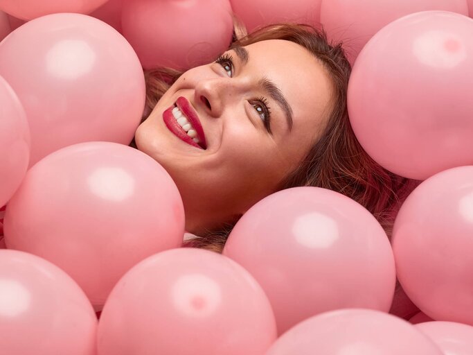 Frau liegt in Luftballons | © iStock | max-kegfire