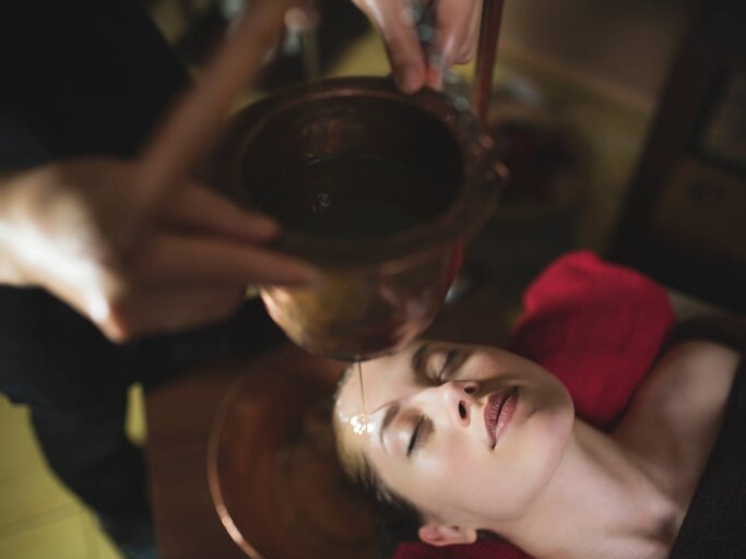 Bei Ayurveda-Massagen kommt warmes Öl zum Einsatz, das in die Haut einmassiert wird. | © iStock | SrdjanPav