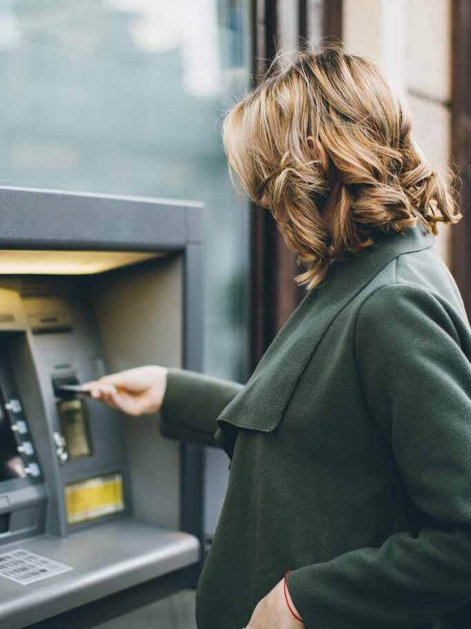 Frau hebt am Geldautomat Geld ab | © iStock | eclipse_images