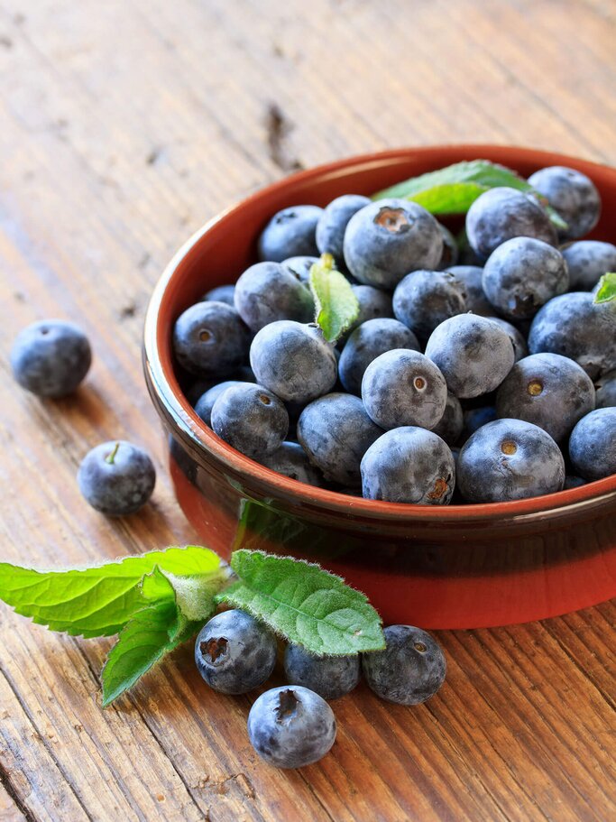 Blaubeeren in einer Schale auf einem Tisch | © iStock | juefraphoto