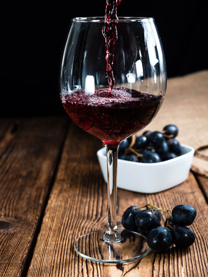 Rotwein, der gerade in ein Glas eingegossen wird | © iStock | HandmadePictures