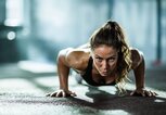 Frau macht Push-Ups im Fitnessclub | © iStock | skynesher