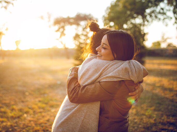 Zwei Frauen umarmen sich im Sonnenuntergang | © iStock | urbazon