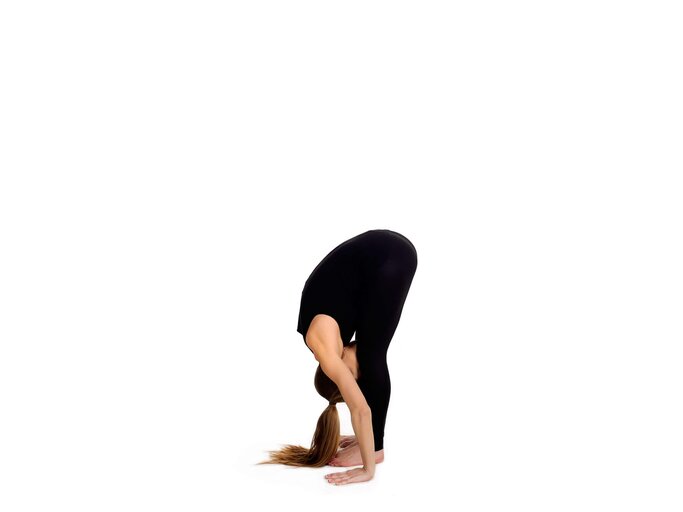 Frau übt Sonnengruß - Uttanasana | © iStock | GoodLifeStudio