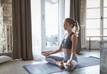 Junge sportliche Frau, die zuhause Yoga praktiziert | © iStock | Jasmina007