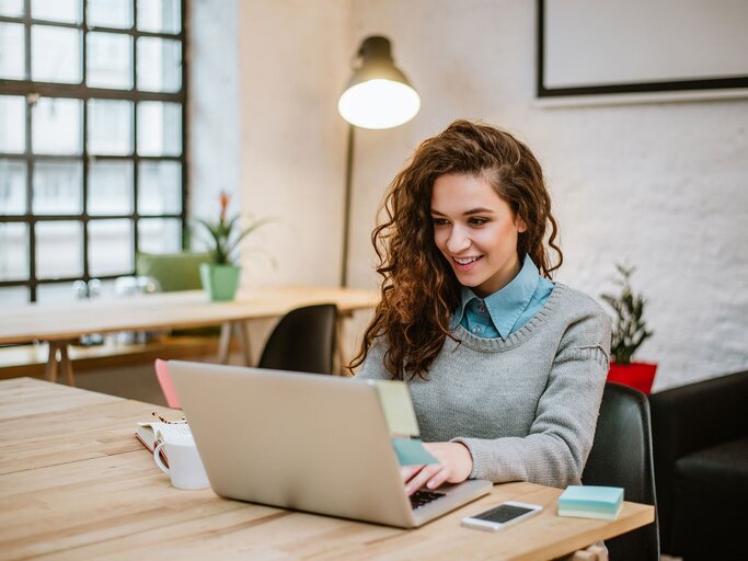 Junge Frau im modernen Büro, die am Laptop arbeitet | © iStock | nortonrsx