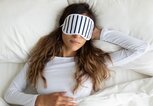 junge Frau liegt mit Schlafmaske im Bett | © iStock | fizkes