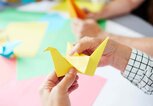 Frau faltet Origami Vogel | © iStock | shironosov