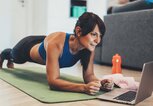 Frau macht ein Workout zu Hause, Planks vor dem Laptop | © iStock | filadendron