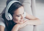 Frau entspannt mit Kopfhörern auf den Ohren | © iStock | Deagreez