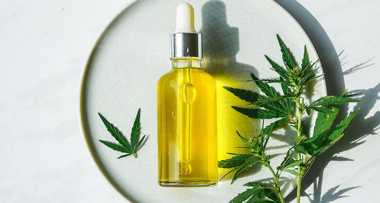 CBD-Öl Flasche auf einem schönen Hintergrund mit einer Hanfpflanze | © iStock | IRA_EVVA