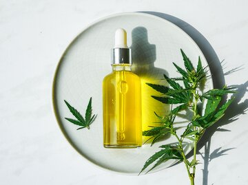 CBD-Öl Flasche auf einem schönen Hintergrund mit einer Hanfpflanze | © iStock | IRA_EVVA