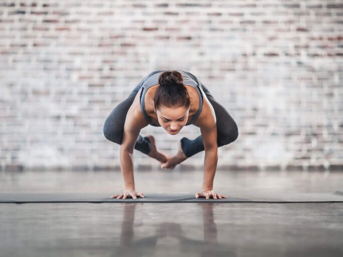 Frau praktiziert die Yoga-Übung "Die Krähe". | © iStock | da-kuk