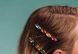 Frau trägt in ihren Haaren zwei Haarklammern mit bunten Steinen. | © iStock | knape