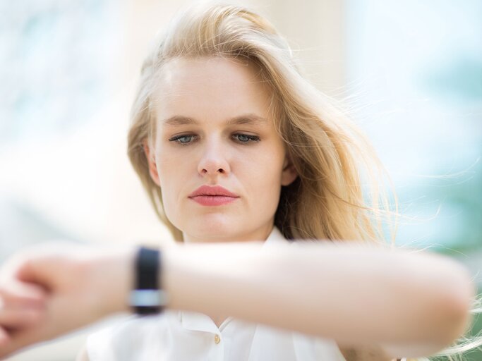 Hübsche Frau schaut auf die Uhr | © iStock | PKpix