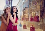 Freundinnen schauen gemeinsam ins Schaufenster | © iStock | praetorianphoto