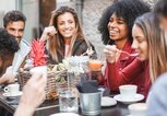 Freunde sitzen gemeinsam in einem Cafe | © iStock | DisobeyArt