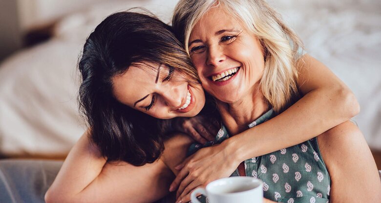 Liebevolle erwachsene Tochter umarmt fröhlich ihre Mutter | © iStock | wundervisuals