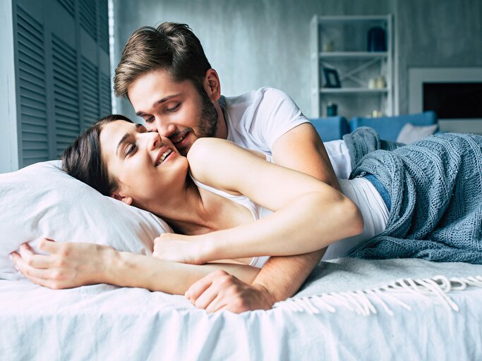 Junges Paar kuschelt im Bett | © iStock | Povozniuk