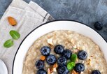 Haferflocken mit frischem rohen Heidelbeere, Mandeln und Honig zum Frühstück. Gesunde vegetarische Kost. Ansicht von oben  | © iStock | YelenaYemchuk