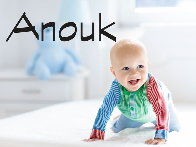 Glückliches Baby krabbelt im Bett - dazu der Name Anouk | © iStock | FamVeld