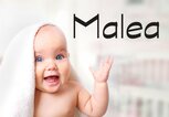 Süßes Baby mit Handtuch auf dem Kopf und daneben der Name Malea | © iStock | NYS444