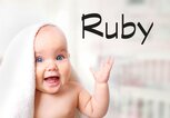 Süßes Baby mit Handtuch auf dem Kopf und daneben der Name Ruby | © iStock | NYS444