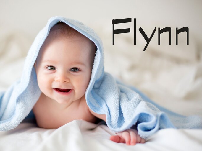 Baby, eingewickelt mit einem Handtuch - dazu der Jungenname Flynn | © iStock | tatyana_tomsickova
