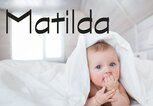 Süßes Baby mit Bettdecke auf dem Kopf und dem Namen Matilda | © iStock | KristinaKibler