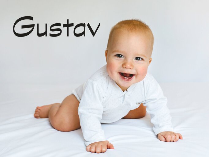 Lachendes krabbelndes Baby mit dem Namen Gustav | © iStock | Vera Livchak 