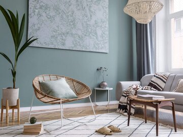 Modern eingerichtetes Wohnzimmer mit einer bunten Wand und gemütlichen Möbeln. | © iStock | FollowTheFlow