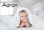 Süßes Baby mit Bettdecke auf dem Kopf und dem Namen Aaron | © iStock.com | KristinaKibler