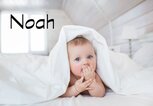 Süßes Baby mit Bettdecke auf dem Kopf und dem Namen Noah | © iStock.com | KristinaKibler