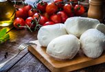 Mozzarella auf einem Brett mit Tomaten | © iStock.com | fcafotodigital